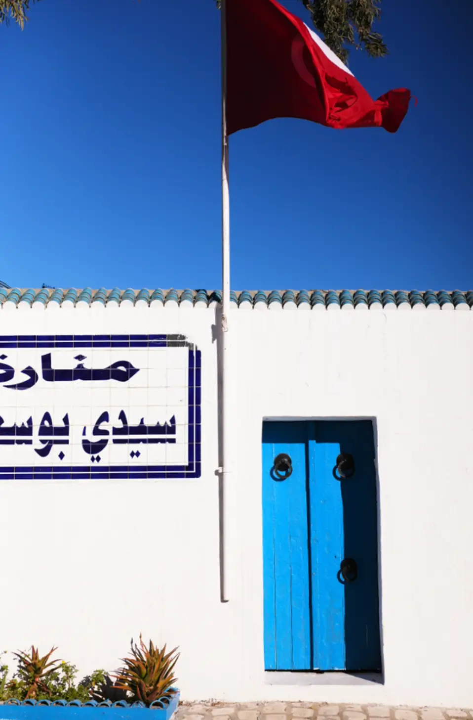 porte bleu et drapeau tunis