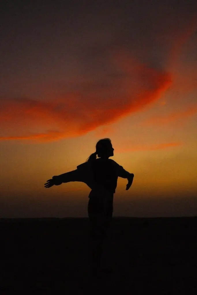 les 10 plus beaux endroits de Socotra femme devant le soleil couchant bras ouverts