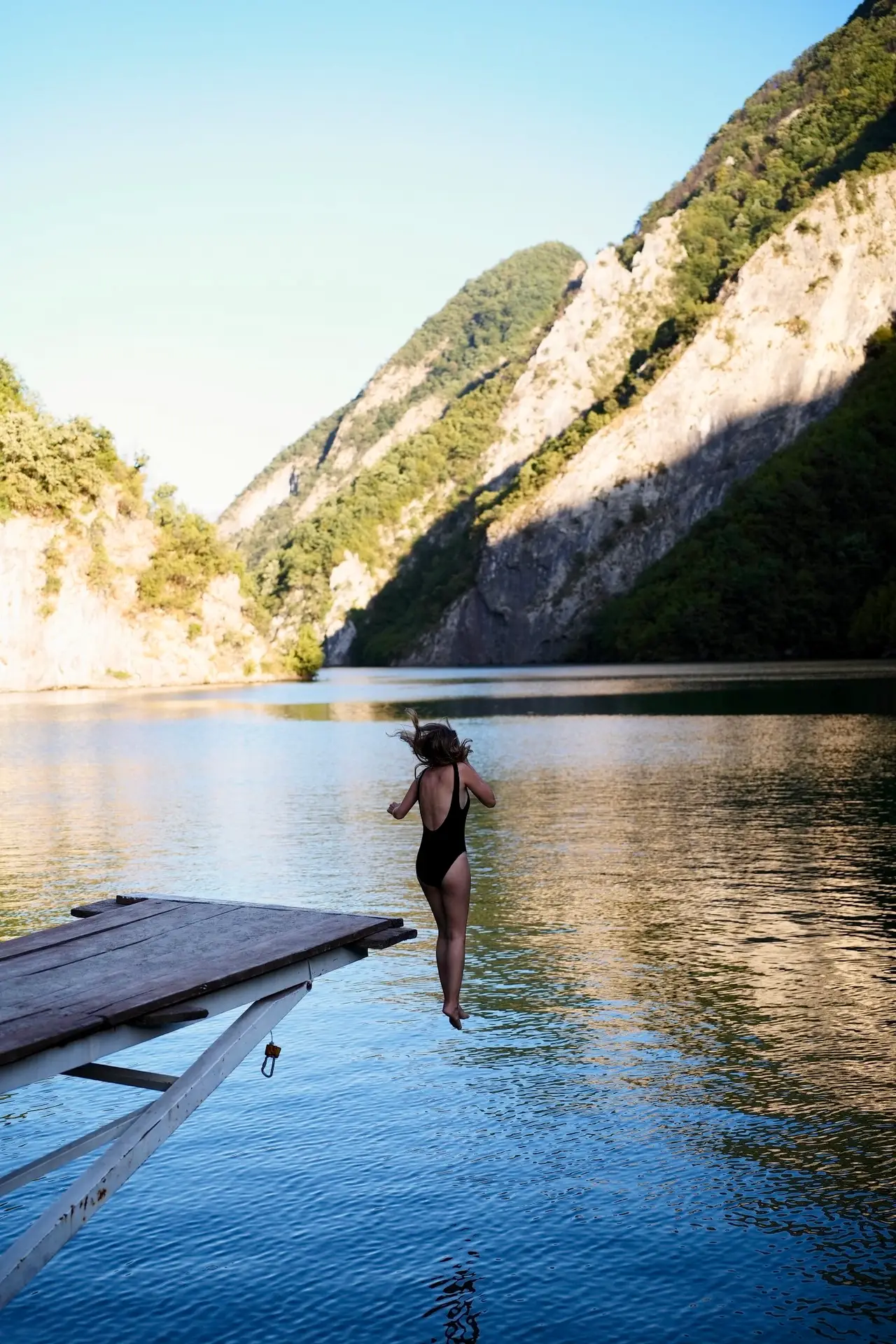 fille qui saute dans l'eau depuis un plongeoir albanie